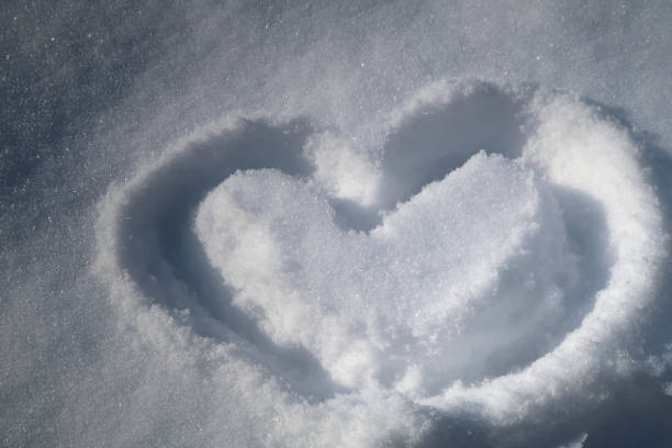 istock Love Symbol - Illuminated Heart Shape In White Snow 1302402946