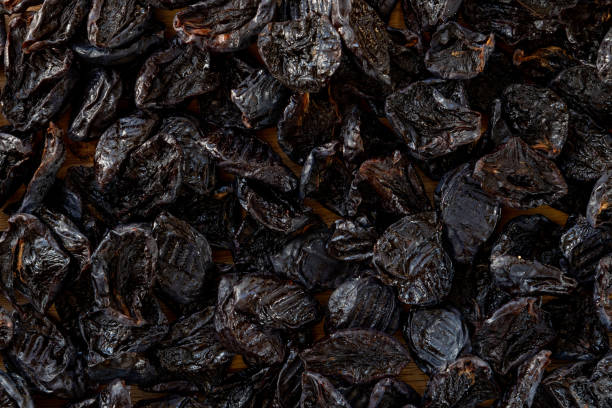 istock Dried plums or prunes fruit background texture. Top view 1302404094