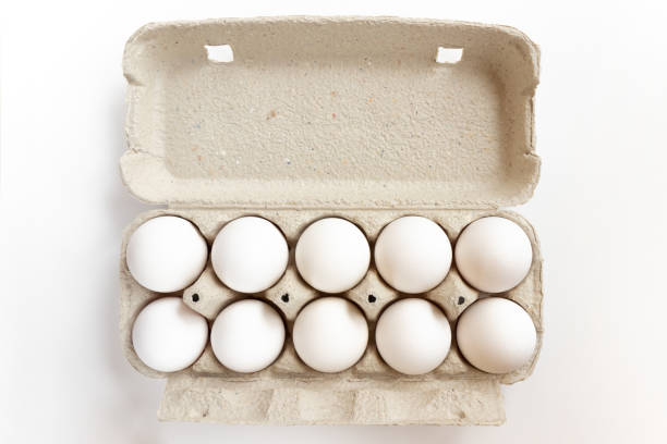 Cardboard egg box with chicken eggs on white background. White chicken eggs in box. Cardboard egg box with chicken eggs on white background. egg carton stock pictures, royalty-free photos & images