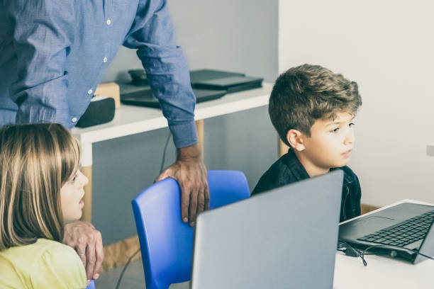 istock Lovely little pupil looking at laptop screen 1302405568
