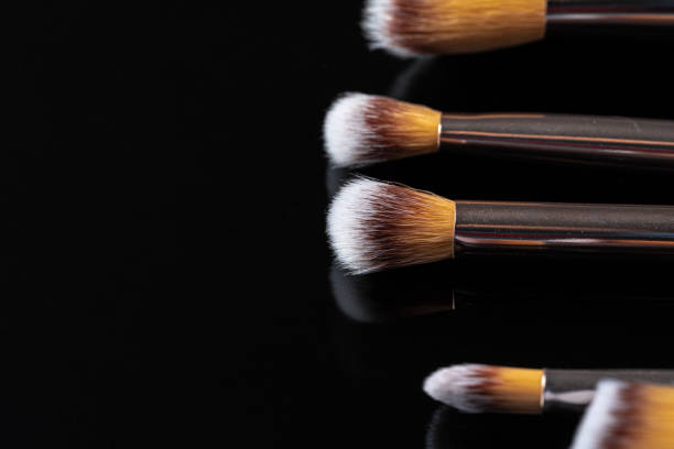 istock Collection of make up brushes on black background 1302405678