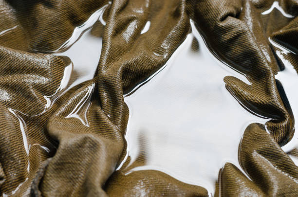 Raindrops beading on waterproof green nylon jacket - extreme close up from above