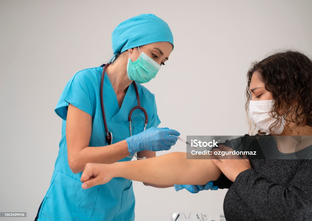 พยาบาลหญิงสวมชุดป้องกันฉีดวัคซีน Covid-19 เข้าที่แขนผู้ป่วย - ไม่มีค่าลิขสิทธิ์ การฉีดยา - ขั้นตอนการรักษาพยาบาล ภาพสต็อก พยาบาลหญิงสวมชุดป้องกันฉีดวัคซีน Covid-19 เข้าที่แขนผู้ป่วย - ไม่มีค่าลิขสิทธิ์ การฉีดยา - ขั้นตอนการรักษาพยาบาล ภาพสต็อก