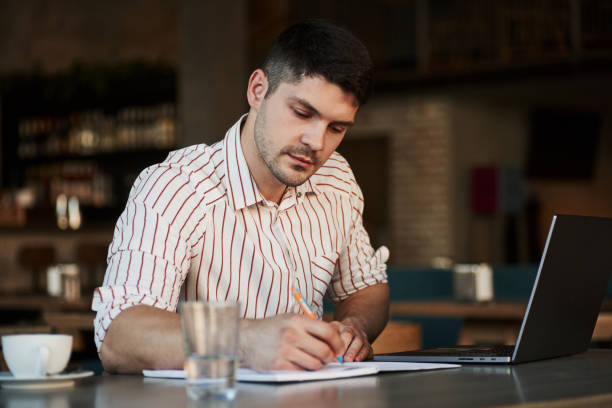 istock Useful notes. Adult man sits in cafe at daytime and using the laptop for the remote work 1302412132