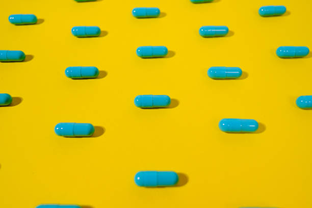 istock Blue pills on a yellow background 1302412890