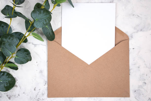 istock Blank white card, envelope and eucalyptus branch on white marble background. Blank invitation. Flat lay. 1302418063