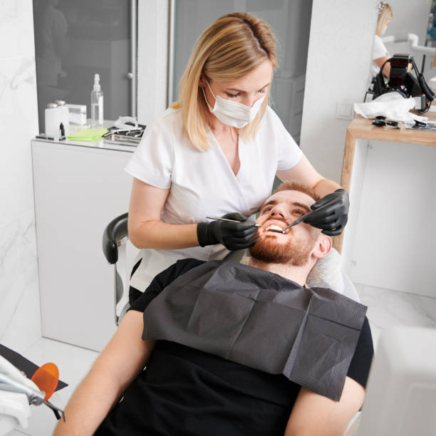 dentista femenino en el trabajo durante el chequeo de dientes del hombre en la oficina del dentista - ambulant patient fotografías e imágenes de stock