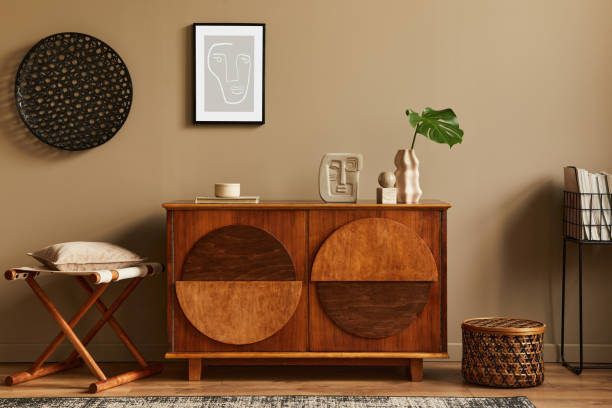 istock Stylish interior with design wooden commode, stool, dried flowers in vase, unique decoration, carpet, mock up poster frame and elegant personal accessories. Modern living room in classic house. 1302419068
