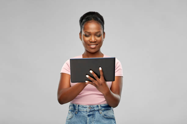 istock happy african american woman using tablet pc 1302420665