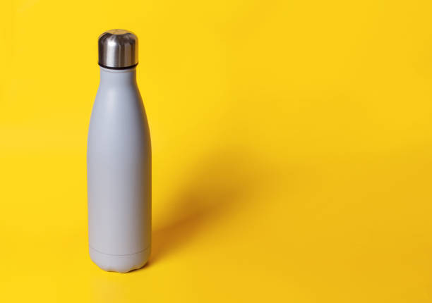 istock Grey reusable steel bottle on yellow background 1302423211