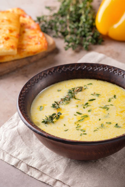 istock Cheese soup with yellow bell pepper and thyme on a beige background. 1302423477