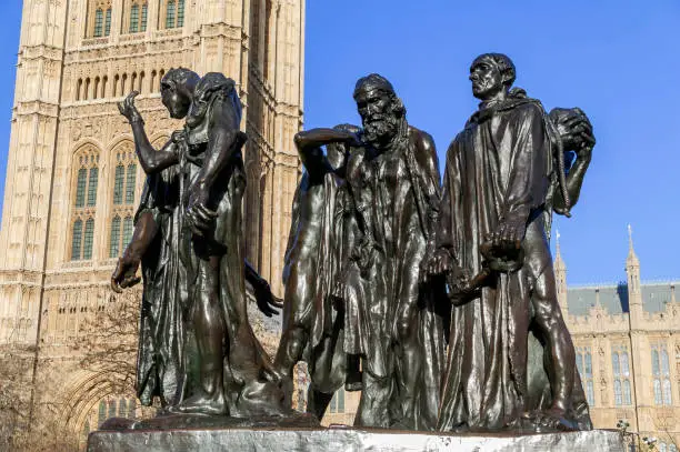 Burghers of Calais statue unveiled in 1915 in Victoria Tower Gardens at the Houses of Parliament  London England UK which is a popular tourist travel destination landmark, stock photo image