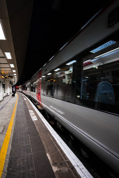 trem moderno com reflexos em janelas esperando em estação ferroviária escura - british rail - fotografias e filmes do acervo