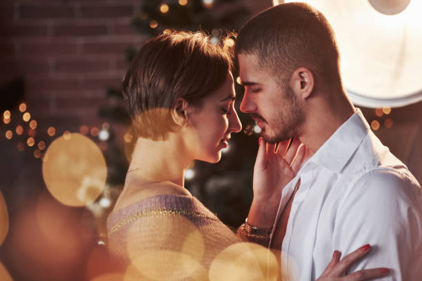 istock Awesome professional artificial lighting. Nice couple celebrating new year indoors with classic beautiful clothes on them 1302427446