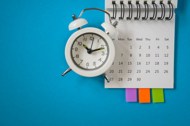 istock white analog alarm clock on white calendar with grunge blue background with copy space, business meeting schedule, travel planning or project milestone and reminder  concept 1302429049