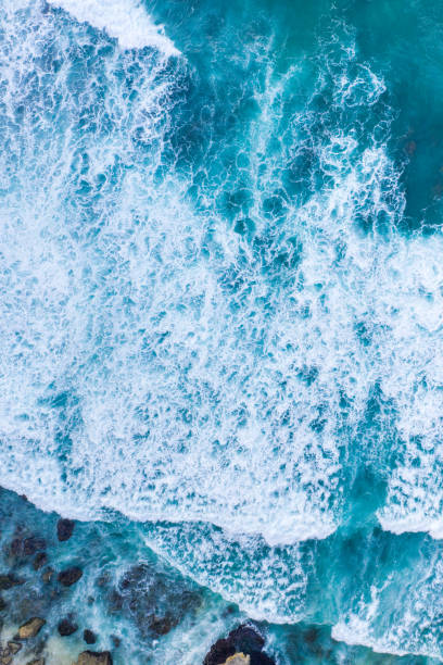 istock Ocean waves hitting a rocky beach. View from above. 1302429070