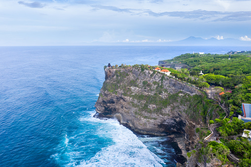 Bali rocky shores on the south Bukit. Ocean waves crashing onto sharp high cliffs. View from above.