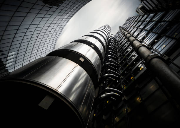 Futuristic dramatic long exposure of modern office building looking up to sky Lloyds Building City of London, England, UK October 29 2020 - Futuristic dramatic long exposure of modern office building looking up to sky dramatic light on glass and chrome shiny metal front lloyds of london photos stock pictures, royalty-free photos & images