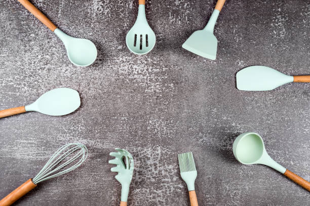 istock Frame made with kitchen utensils, home kitchen tools, mint rubber accessories on dark background. Restaurant, cooking, culinary, kitchen theme. Silicone spatulas and brushes, free space for text 1302432264