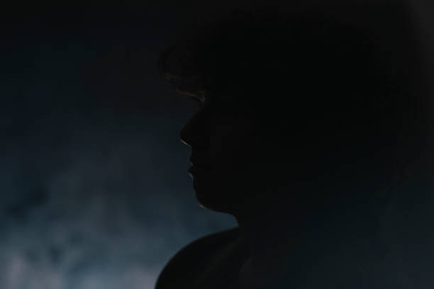 istock Dark Portraits: Silhouette of a Young Woman 1302432276