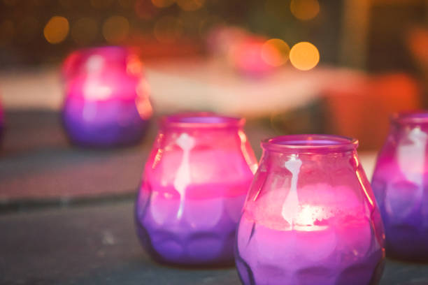 Bright burning purple and pink candles on the table