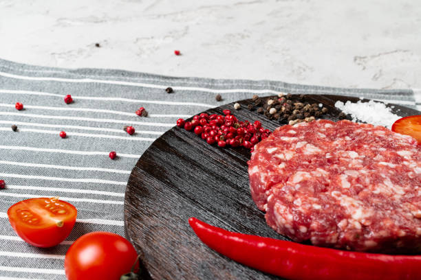istock Fresh raw home-made cutlet with spices and tomatoes on the table 1302433880