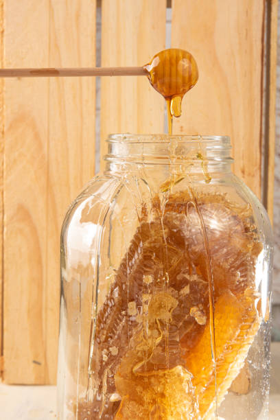 istock Honeycomb, honeycomb jar with honey server. Wooden background, selective focus. 1302434862