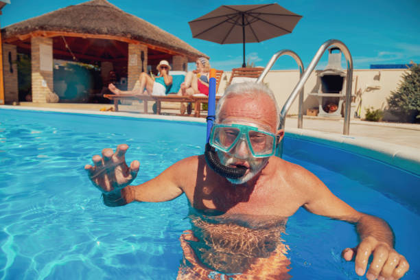 istock Senior man having fun snorkeling in swimming pool 1302435883