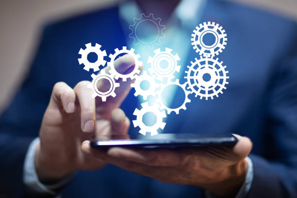 istock man holding gears in phone screen 1302436233