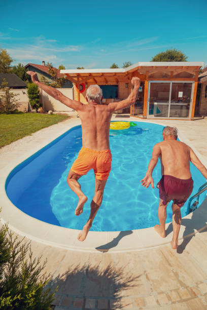 istock Elderly men jumping into the swimming pool 1302436410