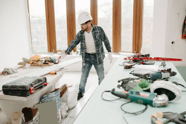 istock Construction worker in a protective helmet among the tools draws drywall in a renovation house 1302438033
