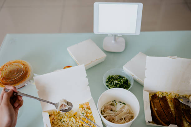 istock Woman watching digital tablet while having take away food at home 1302438741