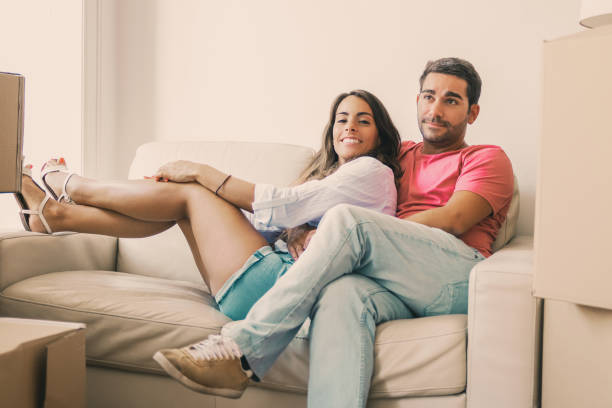 istock Cheerful Latin young couple sitting on couch 1302439283