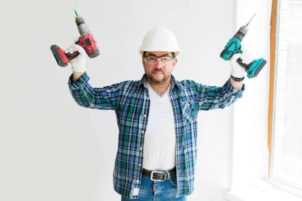 istock Construction worker man in safety helmet with two screwdrivers in construction area 1302439448