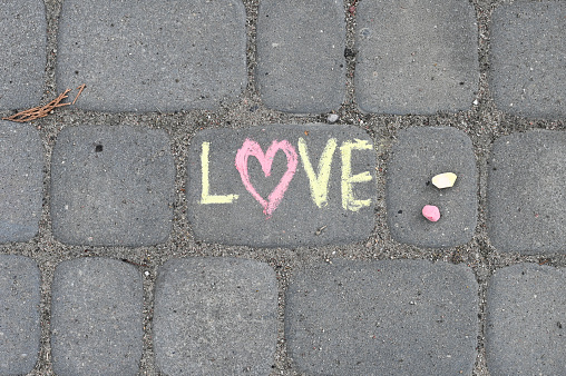 Lettering LOVE made iwith chalk on the road. High quality photo