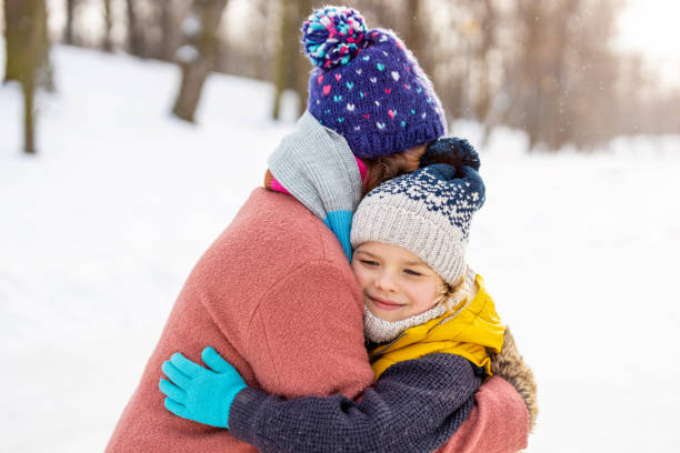 istock Mother and son hugging outdoors in snow 1302446246