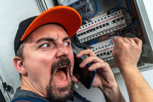 istock Funny electrician checking fuse box and use smart phone 1302446478
