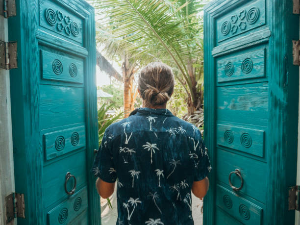 istock Man opening doors of luxury beach villa 1302447229