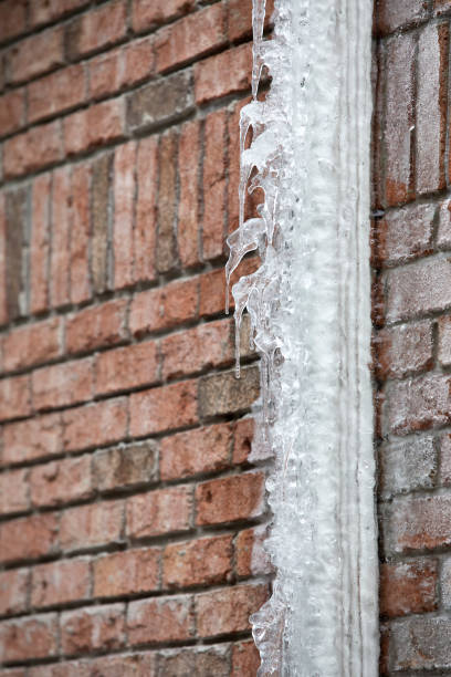 lód zamknięty downspout przed ceglanym budynku - melting ice icicle leaking zdjęcia i obrazy z banku zdjęć