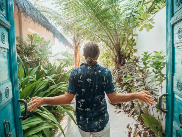 istock Man opening doors of luxury beach villa 1302448598
