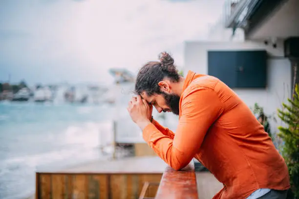 Photo of Depressed Man by the Balcony