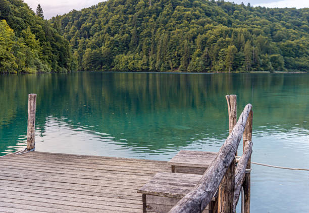istock Wooden pier on a calm evening lake 1302450501