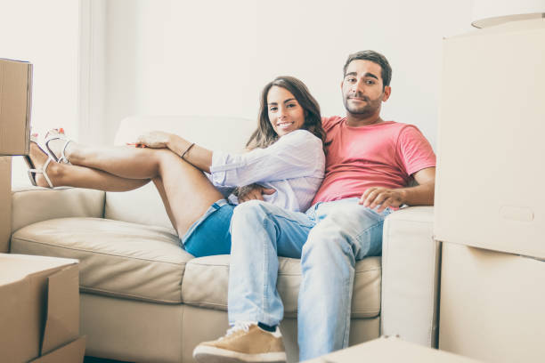 istock Happy Latin young couple sitting on couch 1302450707