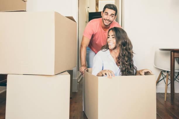 istock Joyful family couple having fun while moving into new flat 1302450744
