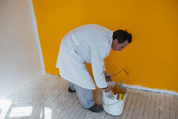 istock Almost done with painting wall yellow 1302451168