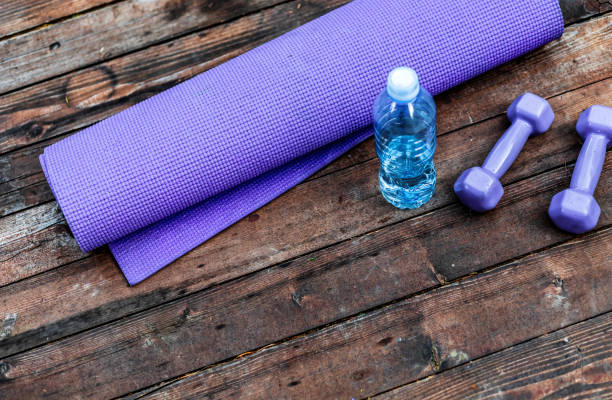istock Dumbbells and yoga mat on wood table 1302451970
