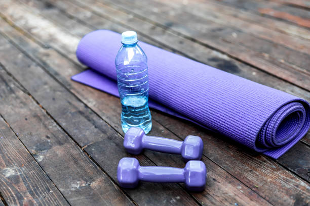 istock Dumbbells and yoga mat on wood table 1302452053