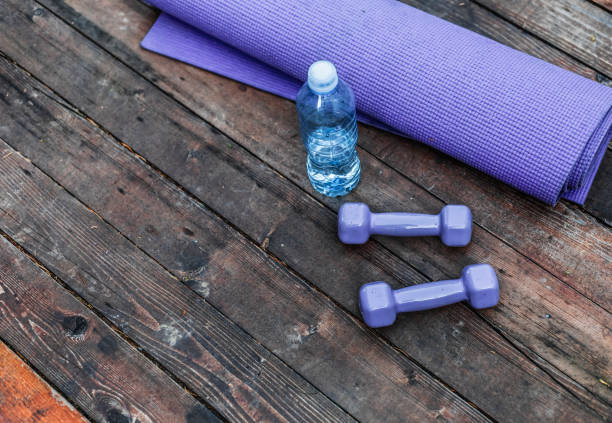 istock Dumbbells and yoga mat on wood table 1302452056