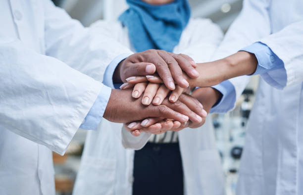 We promise to fight for illness prevention Shot of a group of unrecognisable scientists joining hands in solidarity in a laboratory researcher and doctor stock pictures, royalty-free photos & images