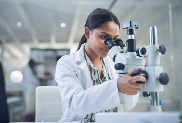 Science opens the door to a better tomorrow Shot of a young scientist using a microscope while conducting research in a laboratory chemistry lab pictures stock pictures, royalty-free photos & images